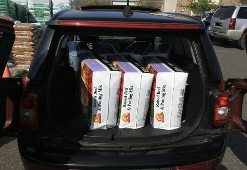 The back of a 2009 Mini Clubman containing 7 3 cubic foot bags of soil.