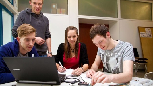 Symbolfoto: Studierende sitzen zum gemeinsamen Arbeiten vor einem Notebook