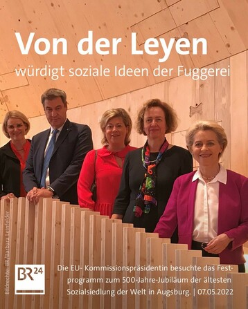 EU-Kommissionspräsidentin Ursula von der Leyen steht unter anderem mit Bayerns Ministerpräsident Markus Söder in einem Pavillon in Augsburg.