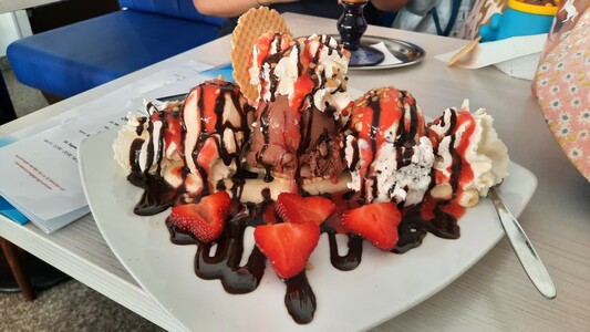 Erdbeersplit. Eisteller mit Banane und Erdbeeren. Dazu Eis und Schokosose.