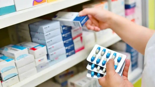 A pharmacist stacking shelves of medication