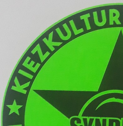 Ein Viertel eines neon grünen Kreises mit der Aufschrift: Kiezkultur  und Synd