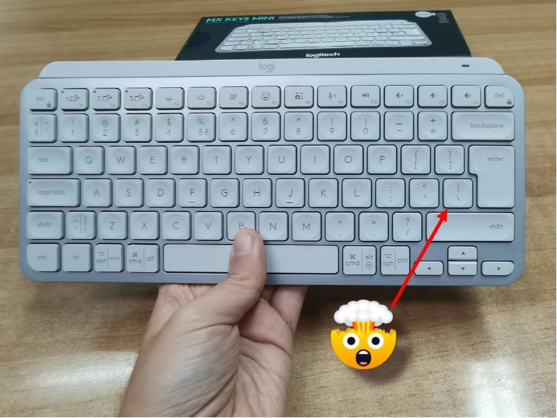 Photo of MX Keys Mini keyboard with the offending key where it shouldn't be marked with a red arrow and an exploding head emoji.