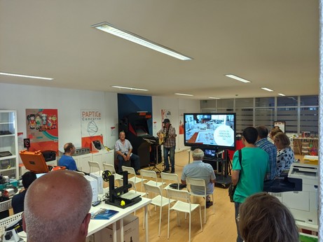 "Foto do espaço Centro Ciência da Computação da ANPRI, com dois músicos em destaque ao centro."