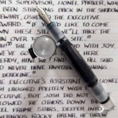 A transparent fountain pen on some text in block letters.