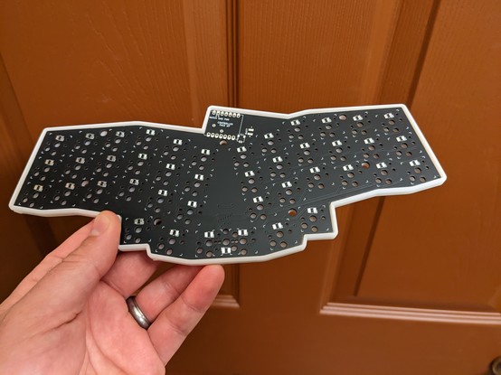 Black revxlp PCB resting in a white resin shell case.