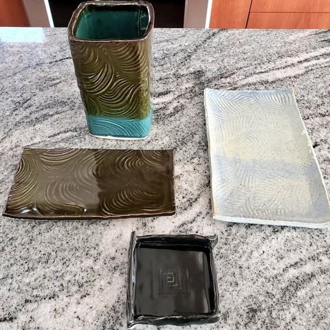 Four pieces of handbuilt potter, a vase, two small platters, and a square ring dish. Various colors, I forgot to write down the glaze combos.