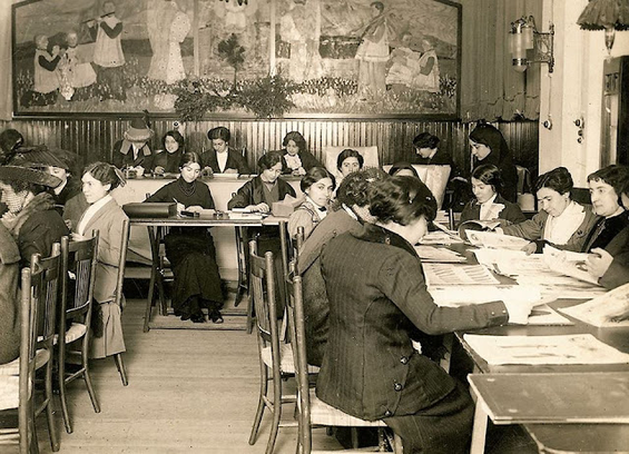 Mujeres leyendo y escribiendo en mesas en L'Institut de Cultura i Biblioteca Popular de la Dona. 1911, Barcelona.