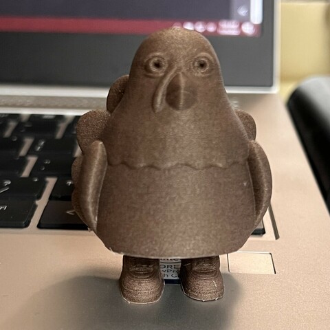 Cartoonish 3-D printed turkey standing on a laptop