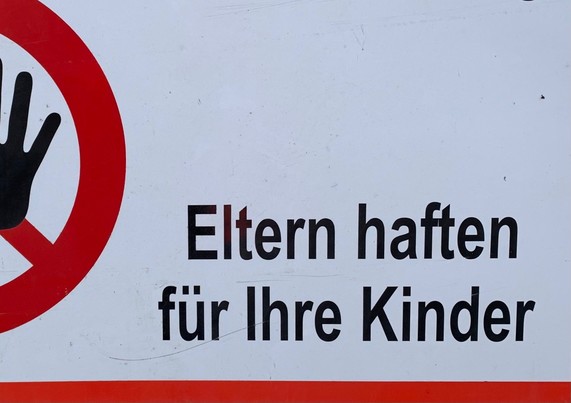Ausschnitt aus einem Schild. Dort steht falsch geschrieben: Eltern haften für Ihre Kinder. Das Wort Ihre muss hier kleingeschrieben werden: ihre