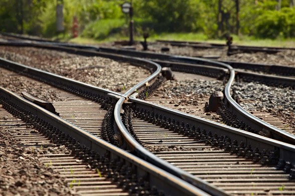 Photo of a railroad switch with one track continuing straight and the other splitting off to a parallel route. Photo credit https://www.freightrailreform.com/wp-content/uploads/2015/03/Rail-Switch.jpg