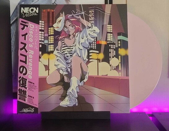 Album cover features an anime girl with pink hair crouching down, raising a mic up near the top of her head. She is wearing a fox mask off to the right side of her face, glasses, and has on a white jacket, skirt, leg warmers, and shoes, as well as a white and black striped tank top. 

There is a city scape behind her. The left side of the album cover features a black and pink obi strip feature artist, album, and track names. 

Vinyl variant color is an opaque light pink