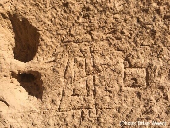 Photo of rough carving in stone, showing a technical sketch of an obelisk still lying in the quarry and lines indicating where levers would be needed to raise and move the stone.