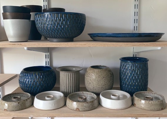 Some wheelthrown pots on a shelf. 