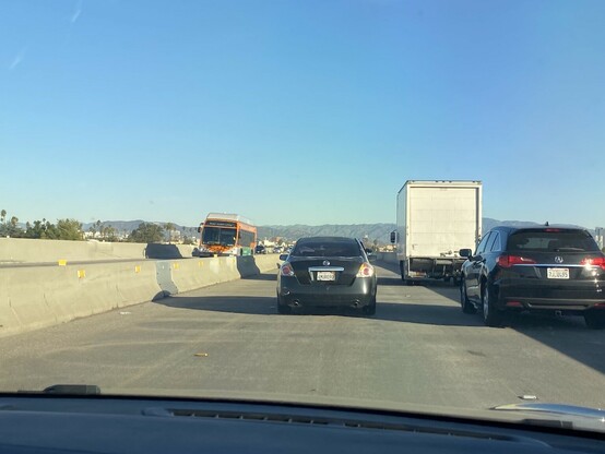 Carpool/Express Lanes heading to LA Downtown. With traffic. With clear skies   Hollywood Sign to the left in the distance.
