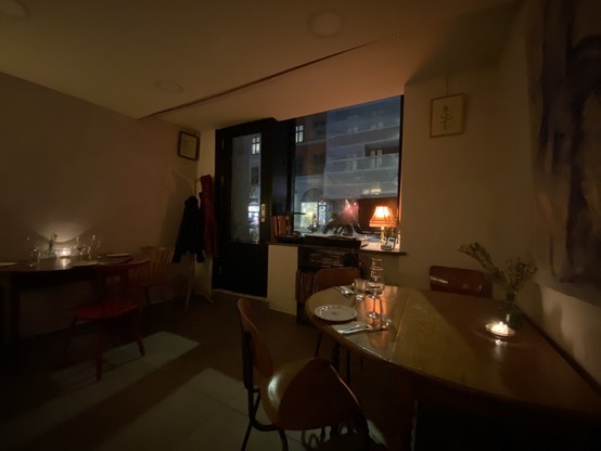 Small, dark restaurant with candles on the tables. Tables are mismatched. It all has a homey vibe.