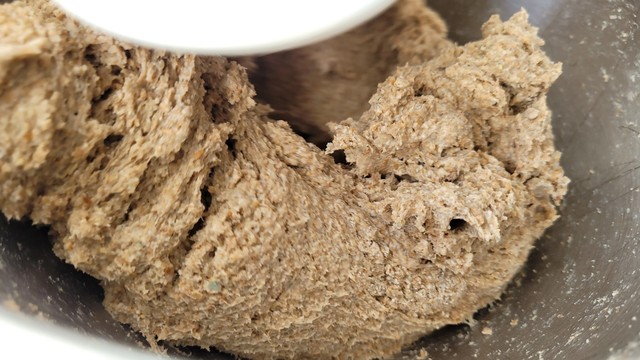 Man sieht, wie die Bestandteile in der Maschine mit Knethaken verknetet werden. 