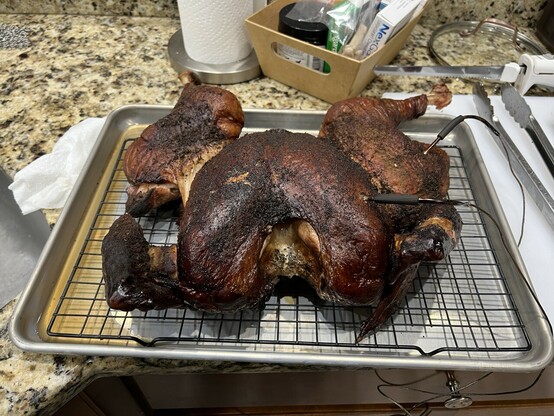 Mahogany colored, spatchcocked smoked Turkey fresh off the grill. 