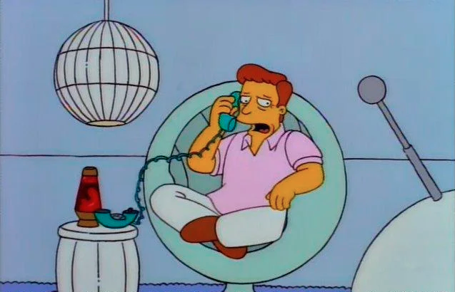 Image de Troy McClure des "Simpsons", au téléphone, assis dans un fauteuil retro-futuriste, en train de poser une question.