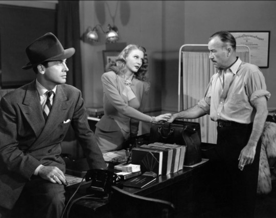 Actors Robert Armstrong and Edward Norris with actress Jean Gillie in the 1946 noir film “Decoy“.