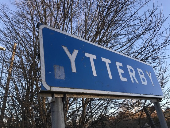 A photograph of a road sign for Ytterby, with white lettering on a blue background 