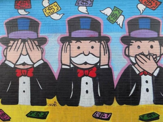 ⸻
Erinnert wohl nicht zufällig an die drei Affen.
⸻
<ALT> Das Graffiti zeigt die Monopoly-Symbolfigur (ein Banker) in dreifacher Ausfertigung: ein Banker hält sich die Augen zu, der zweite die Ohren, der dritte den Mund.
⸻
⸻