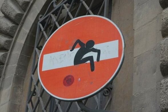 ⸻
Zu Fuß geht es in beide Seiten (Florenz, Italien).
⸻
<ALT> Das Graffiti zeigt ein Einbahnstraße-Schild; auf dem Querstreifen in der Mitte steigt eine (gesprühte) Figur.
⸻
⸻