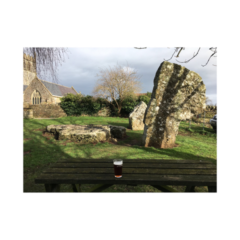 The remains of a neolithic burial chamber in the pub garden: two upright stones and one lying flat in the ground