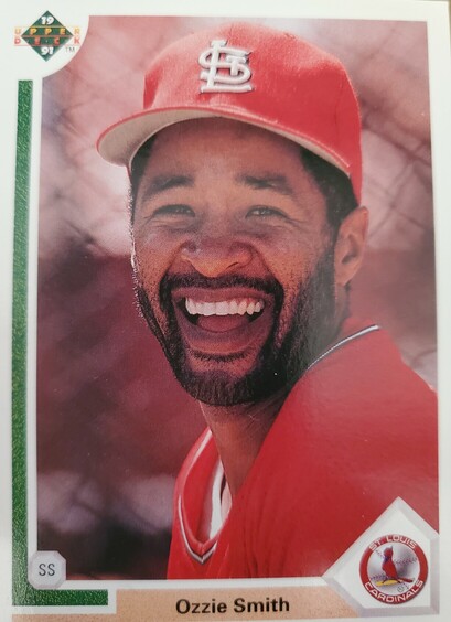 Photo of baseball player Ozzie Smith laughing. He is wearing a red St. Louis Cardinals uniform. 
