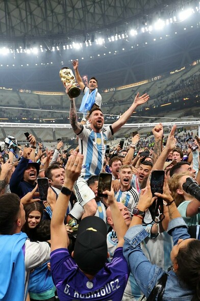 Messi on the shoulders of a teammate cheering and celebrating!