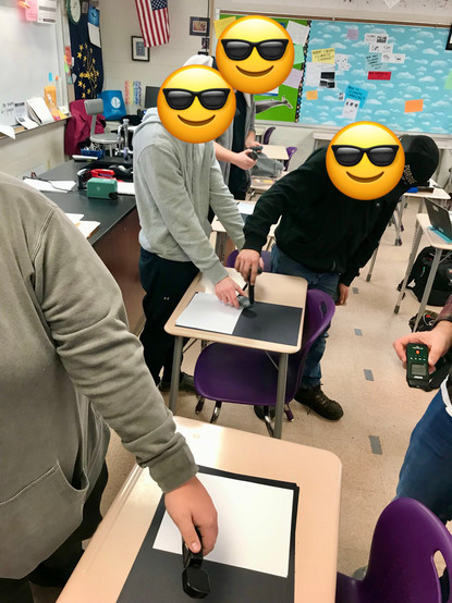 Students use solar irradiance meters to prototype albedo experiments in a high school classroom