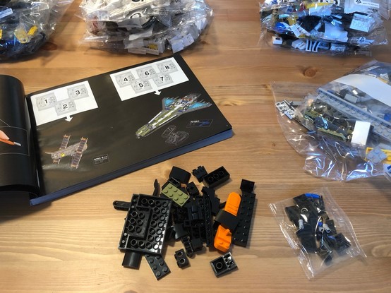 The set open up with the instruction manual and pieces on the table. 