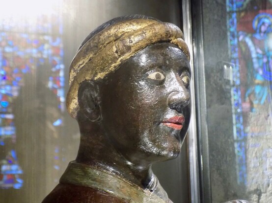 Gros plan sur le visage de la Vierge Noire portant turban oriental doré.
