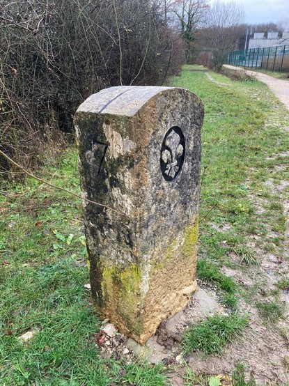Border stone number 7, with a glimpse of an industrial site top right.