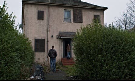 Scene from Under the Skin. Woman opening door to a rundown house. A man follows her inside 
