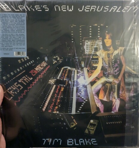 The album cover for Blake's New Jerusalem, on which musician Tim Blake sits in front of a vast sea of backlit dials and consoles and undulating wires plugged into the patch bays of modular synthesizers.