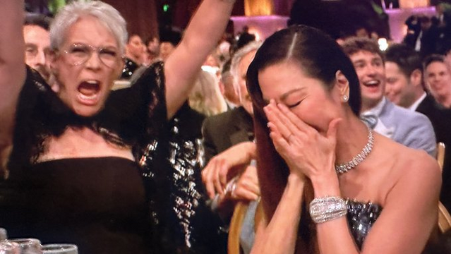 Michelle Yeoh with her hands over her face. Jamie Lee Curtis with her arms in the air, exclaiming with joy.