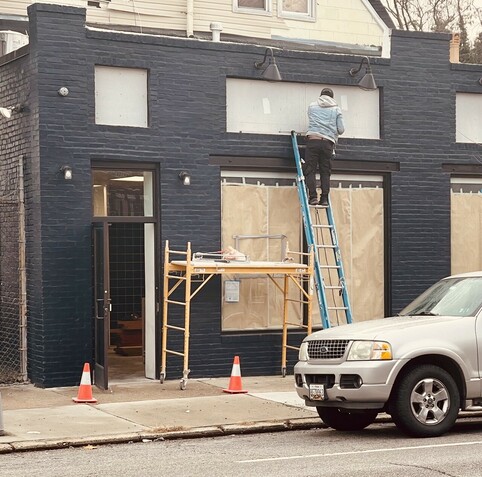 A man is preparing a storefront on Greenmount Avenue in Baltimore 