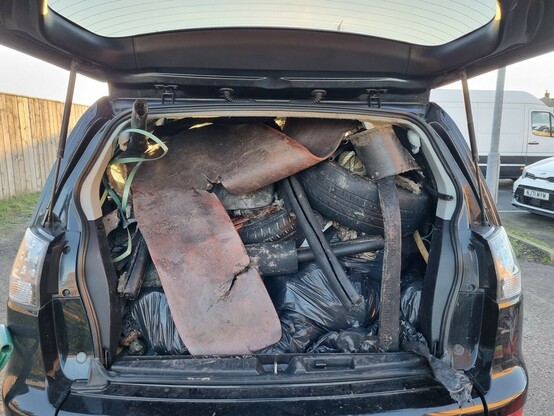 Car boot and back seats stuffed with rubbish