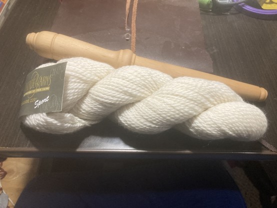 a new hank of wool yarn and an empty nøstepinde