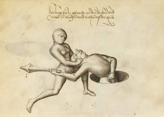 Man in a hole is pulled backwards by woman who grabs his ears form behind. 