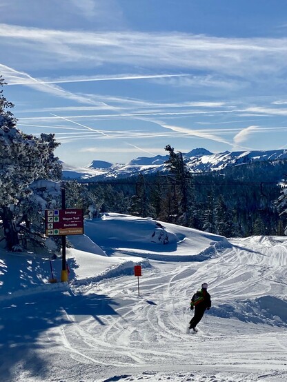 The top of the ski lift with snowy mountains in the distance 