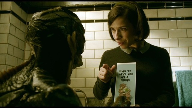 Sally Hawkins giving the sea creature a card that reads 'glad to have you as a friend.'