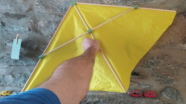 My arm stretched out holding the large yellow 1 meter wingspan Rogallo wing prototype.