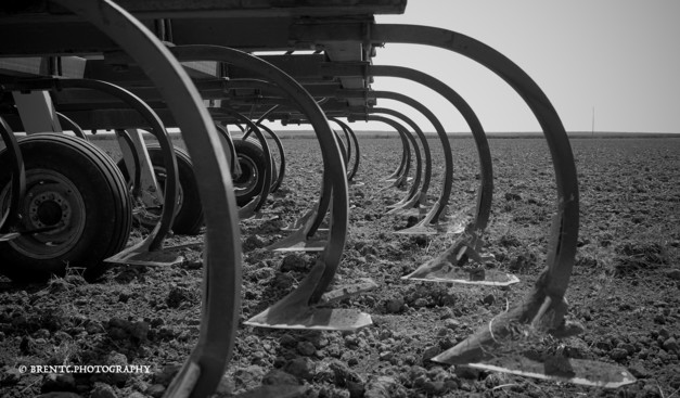 Black and white photo of farm machinery and a dirt field in Nebraska
