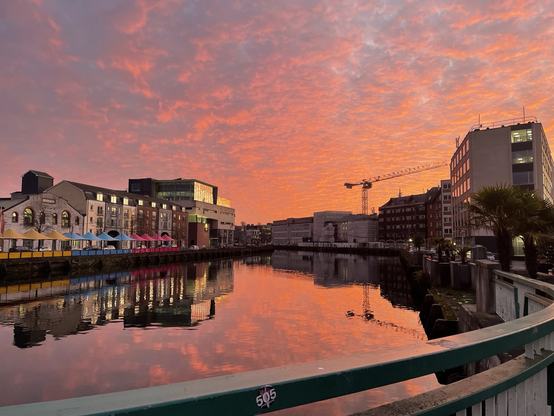 Reflections of a sunset over Cork buildings & river. 