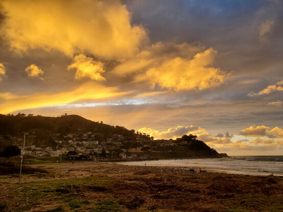 Brilliant orange paint-work on the clouds as Old Sol dips toward the horizon.  Streaks of vivid sky blue peek through the clouds,
