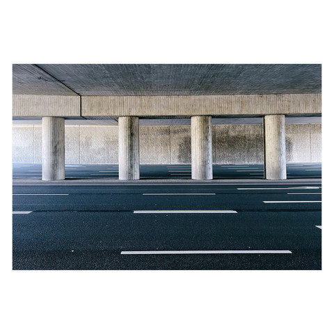 Straße unter einer Unterführung. Im Hintergrund große Sülzen die die Decke der Unterführung tragen. 