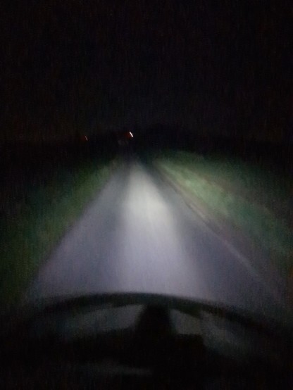 Feldweg von Helmlampe ausgeleuchtet. Sechs Uhr morgens.