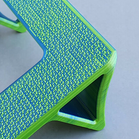 A closeup of the Hilbert curve finish on the Steam Deck Dock mentioned in the post, printed with 3DJake magicPLA Parrot (yellow-blue) filament.